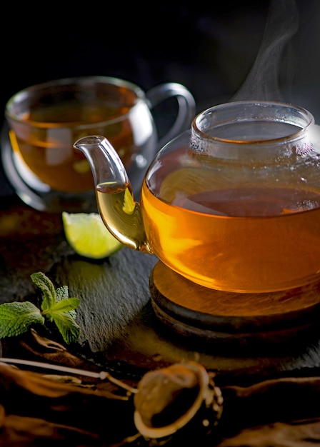 Tea concept, teapot with tea surrounded on wood table tea ceremony, green tea in a transparent cup