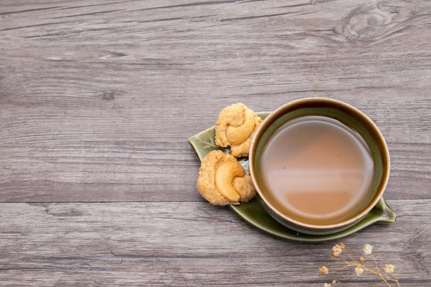 木製のヴィンテージの背景にお茶とクッキー、クッキーとお茶のカップの上面図、コピースペース。