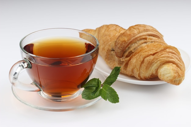 Tea and croissant on a white