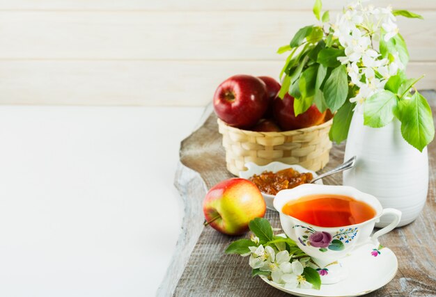 Tea cup and apple jam on wooden table