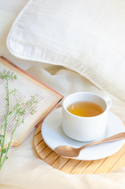 Tea cup next to book and leaves Relax moment