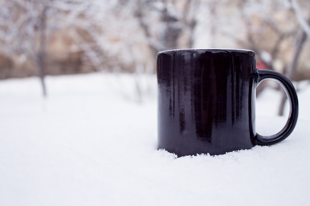 雪の上のティーカップ。冬の背景。