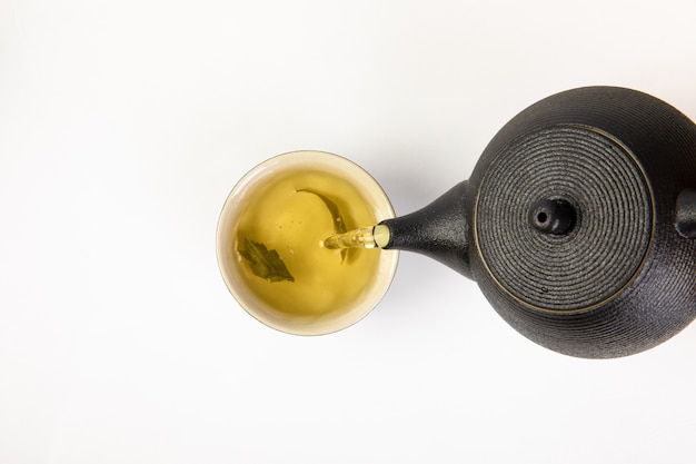 Tea in a cup and teapot on white background