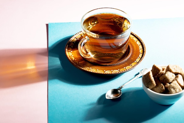 Tea in a cup with dessert on a bright colored background