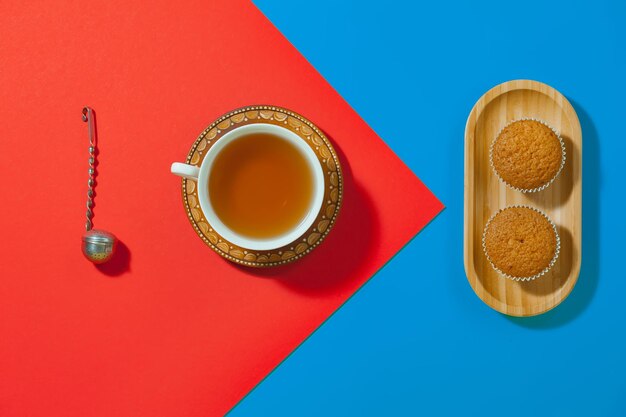 Tea in a cup with dessert on a bright colored background