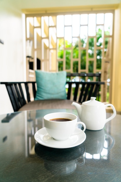 Tea cup with teapot on table