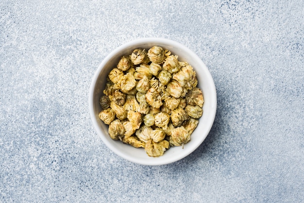 Tea flowers for brewing in bowl on a gray background