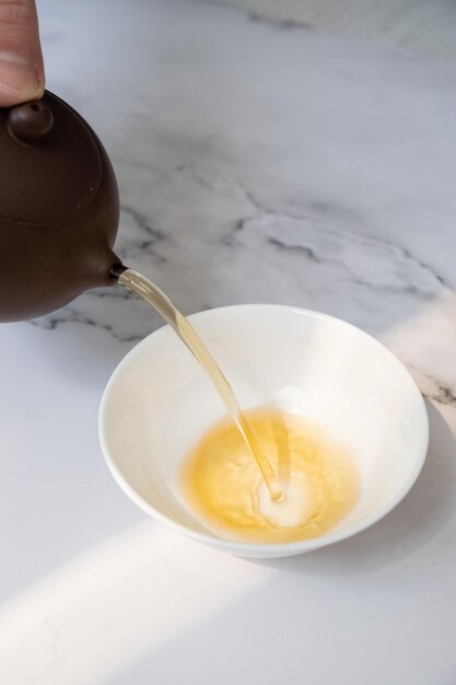 Tea from the teapot is poured into a cup Tea ceremony concept