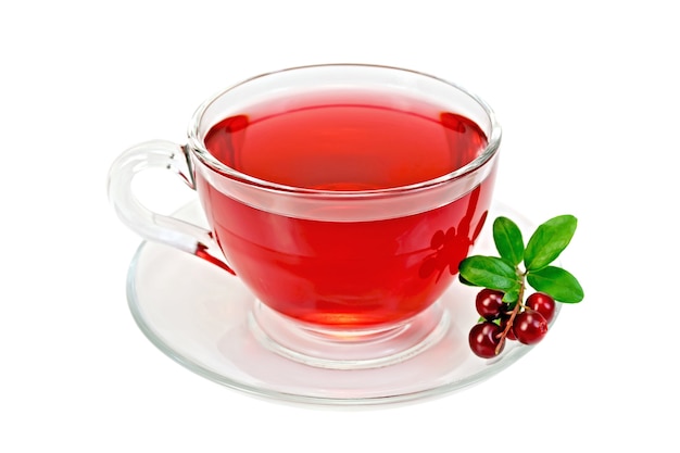 Tea in a glass cup, berries and green leaves cowberry isolated  