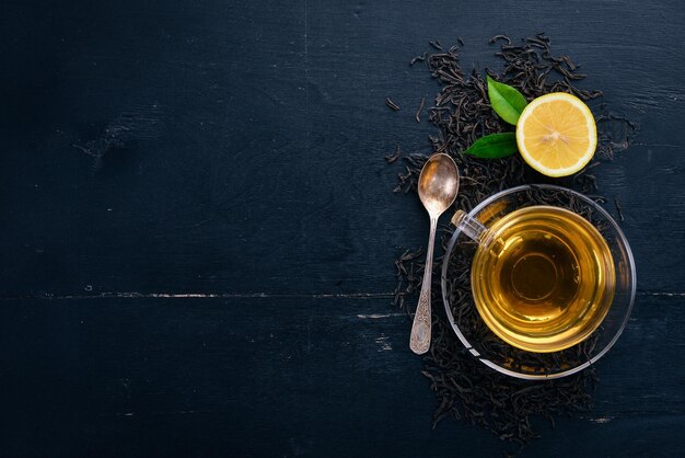 Tea in a glass cup with spices and herbs On a black wooden background Top view Copy space