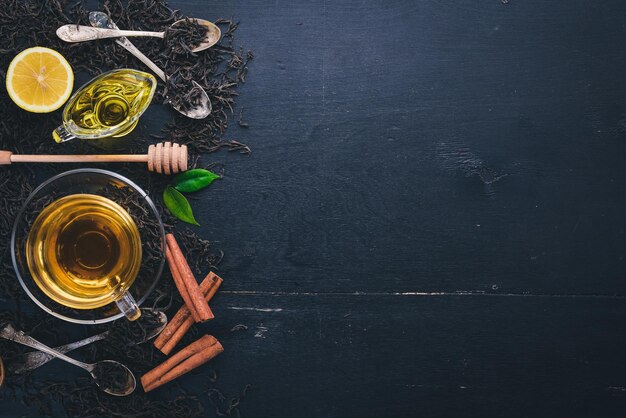 Tea in a glass cup with spices and herbs On a black wooden background Top view Copy space