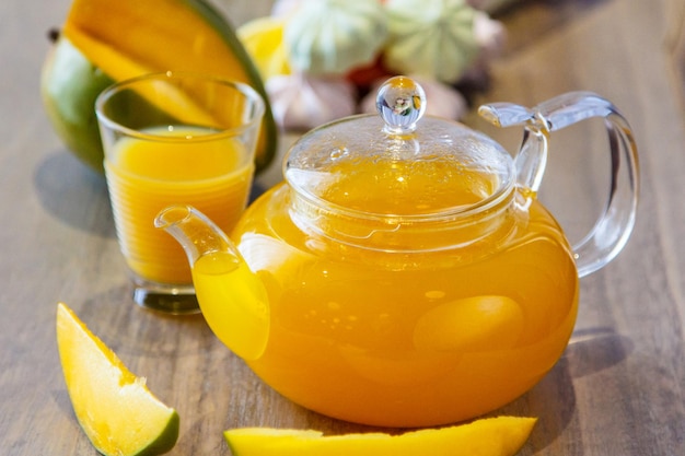 Tea in a glass teapot of mango and berries