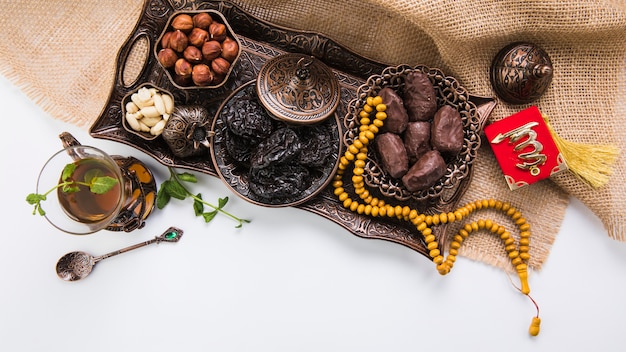 Photo tea glass with dried fruits and beads on canvas