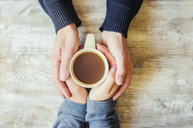 Tea in hand. The lovers are together. Selective focus.