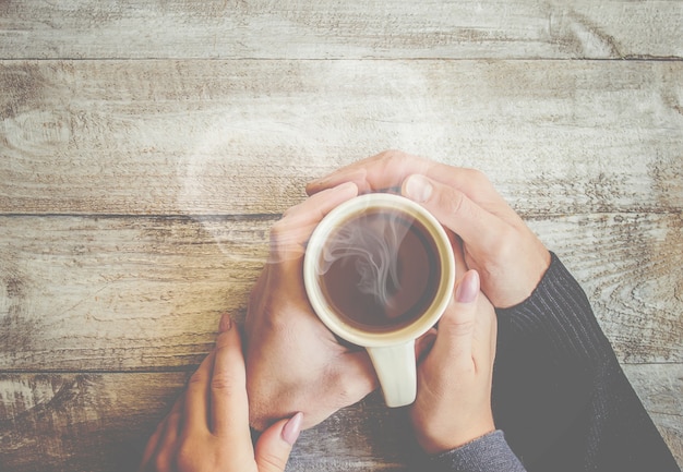 Tea in hand. The lovers are together. Selective focus.