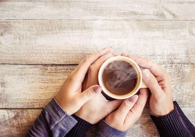 Tea in hand. The lovers are together. Selective focus.