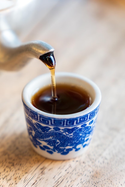 The tea is poured onto the tiled glass from the teapot