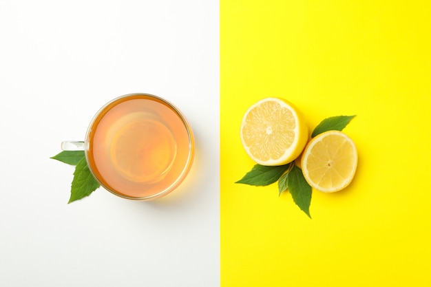 Tea and lemon on two tone surface. Ripe fruit