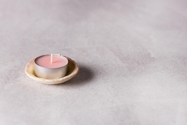 Tea Light Candles on Shell Light Gray Background Copy Space