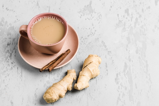 Tea masala in a Cup on the plate with the winter spices of cinnamon and ginger 