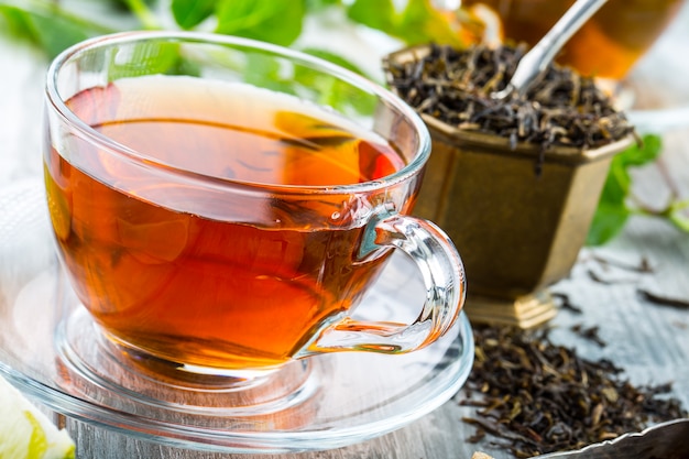 Чай. Мятный чай. Травяной чай. Листья мяты. Мятные листья. Чай в стеклянной чашке, листья мяты, сушеный чай, нарезанный лайм. травяной чай и листья мяты на грифельной тарелке в ресторане или чайной чайной