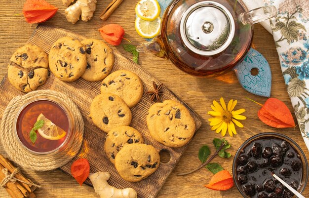 Concetto di tea party con biscotti dolci con briciole di cioccolato su un tavolo di legno vista dall'alto