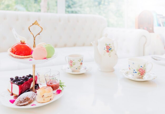 Tea set and cake placed on a white marble table