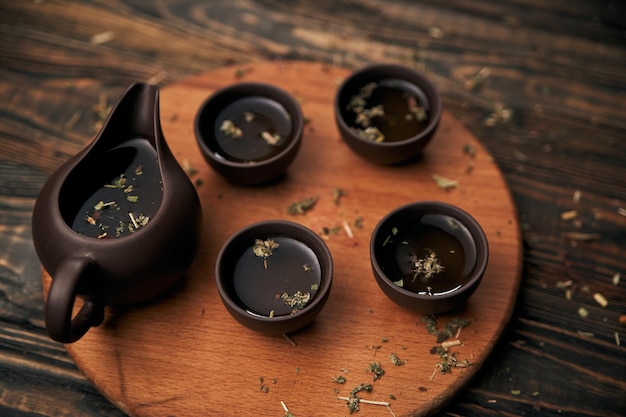 Tea set and tea leaves on wooden background