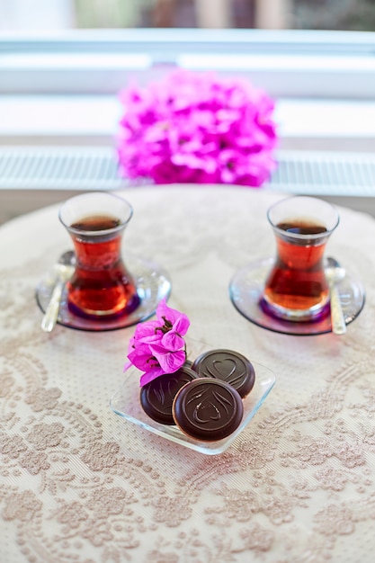 クッキーとテーブルの上の伝統的なトルコのガラス茶グラスのお茶。