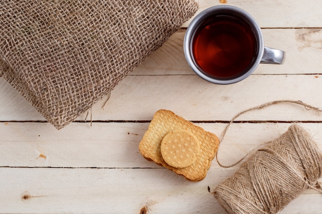 Tea in vintage mug and cookies on table