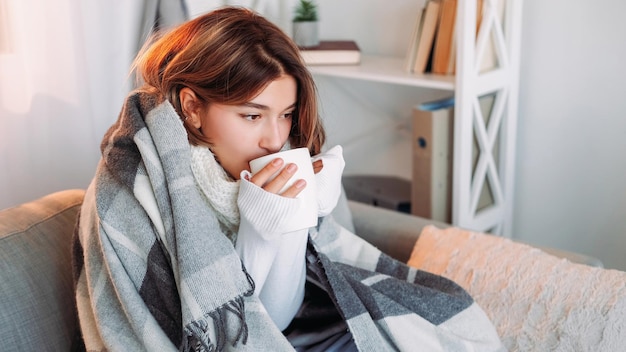 お茶を飲む温休 秋を飲む 寒くて震える女性