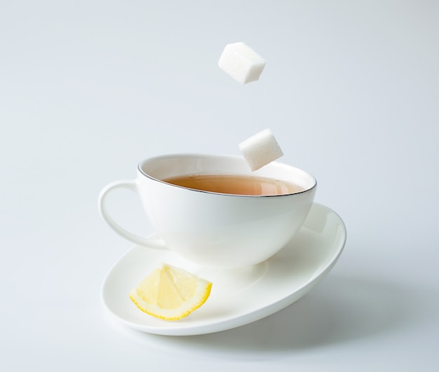 Tea in a white cup with lemon and sugar. balance and levitation.