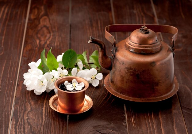 Tea and white spring flowers on a wooden table