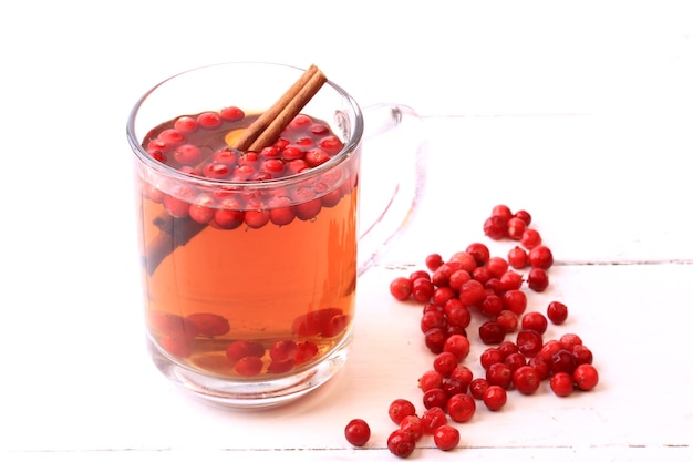 Tea with cranberry and cinnamon on a white wooden background Christmas