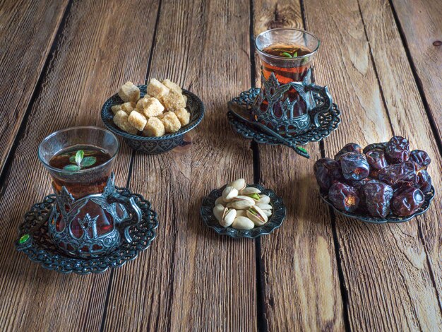 Tea with dates on a dark wooden table.