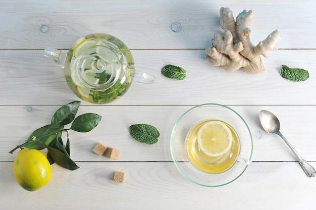 Tea with lemon, ginger and mint in a glass Cup, teapot and tea spoon 