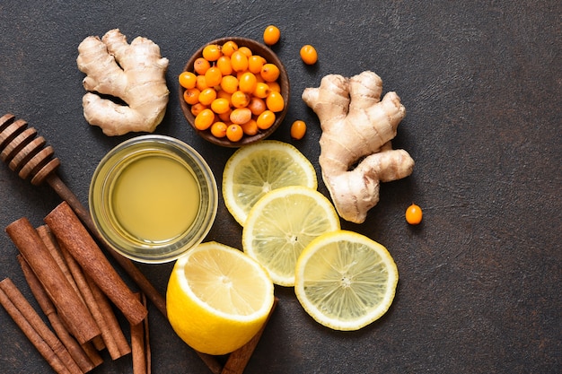 Tè al limone, miele e cannella. ingredienti per preparare il tè. bevanda calda invernale con zenzero e olivello spinoso.