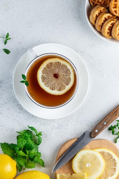 Tea with lemon in a white mug on the table