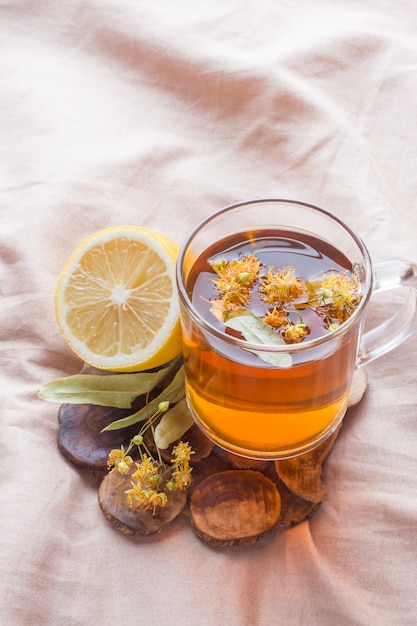 Tè con tiglio, miele e limone. il vassoio sul letto, il concetto di trattamento del raffreddore