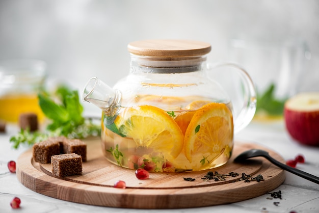 Tea with orange and apple in a glass teapot