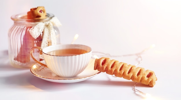 Tea with pastries for breakfast. Sweets and pastries with nuts for tea on white background. A coffee cup and patties.