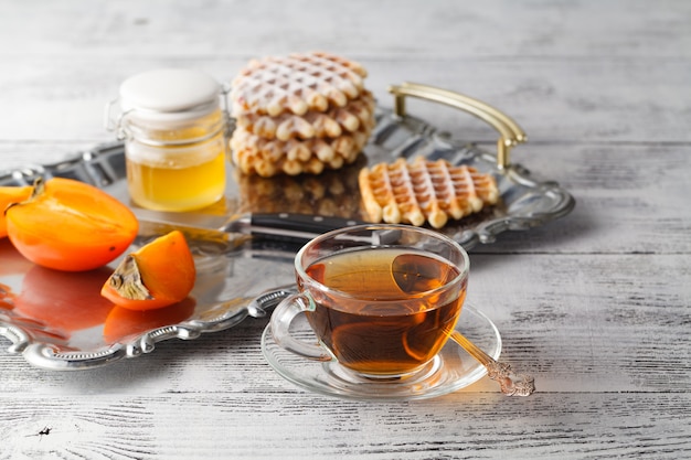 Tea with persimmon on iron tray