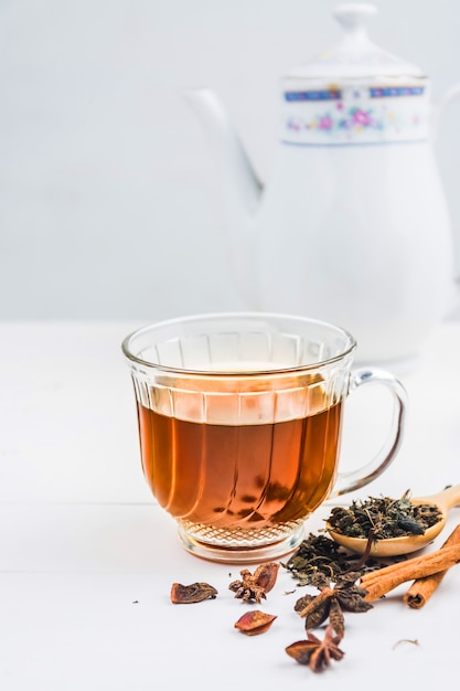 Tè con bicchiere di tè su legno bianco
