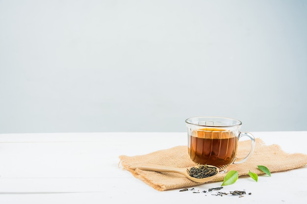 Tè con bicchiere di tè su legno bianco