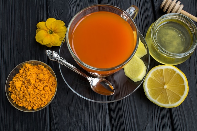 Tea with turmeric on the black  wooden surface.View from above.