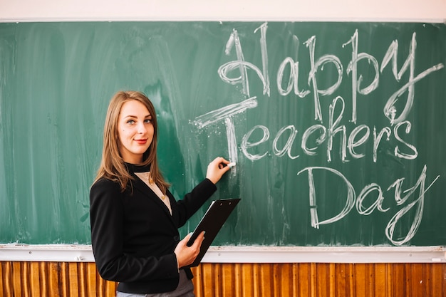 Teacher at blackboard with inscription