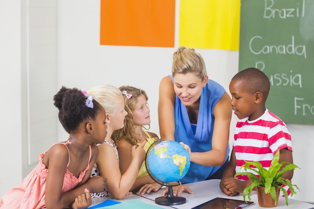 Teacher discussing globe with kids