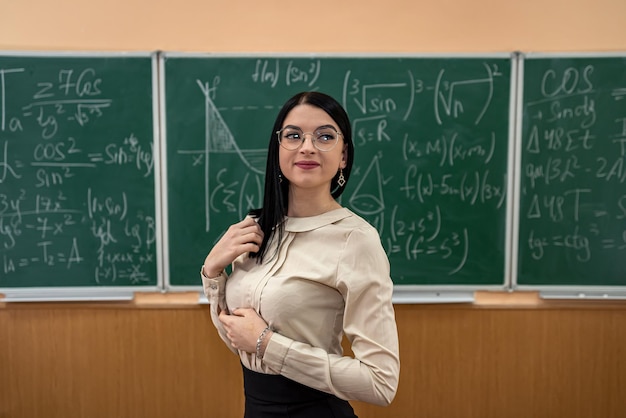 teacher explain completing mathematical equations on chalkboard in classroom. studying concept