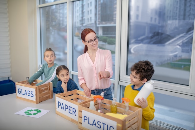 The teacher explaining to pupils how to sort the waste