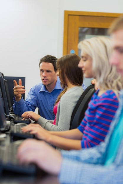 Teacher explaining to students in the computer room